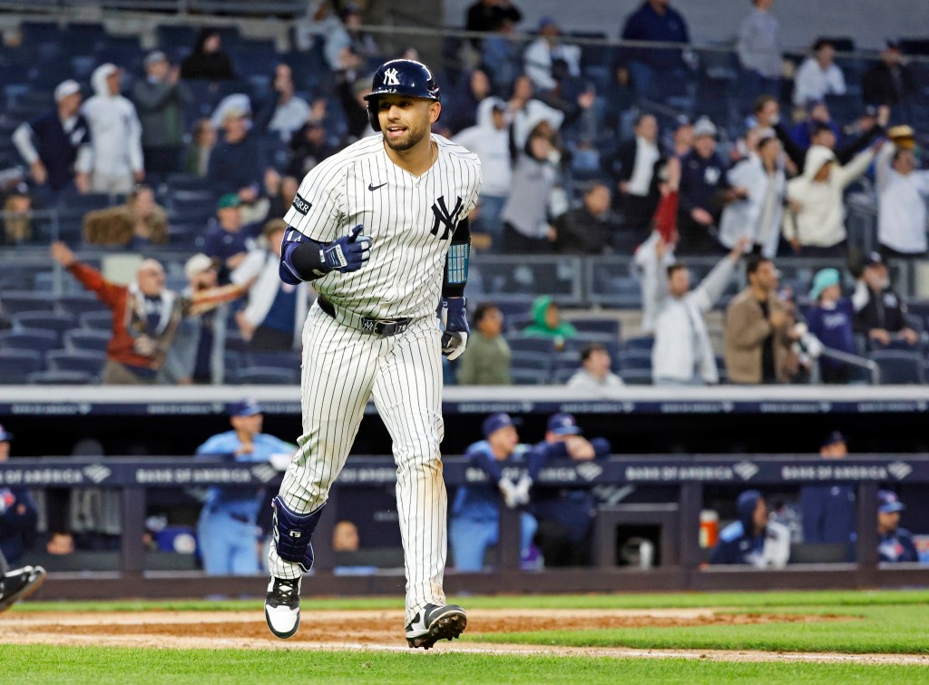 J.C. Escarra #25 of the New York Yankees smiling and running the bases after hitting his first home run at Yankee Stadium against the Toronto Blue Jays