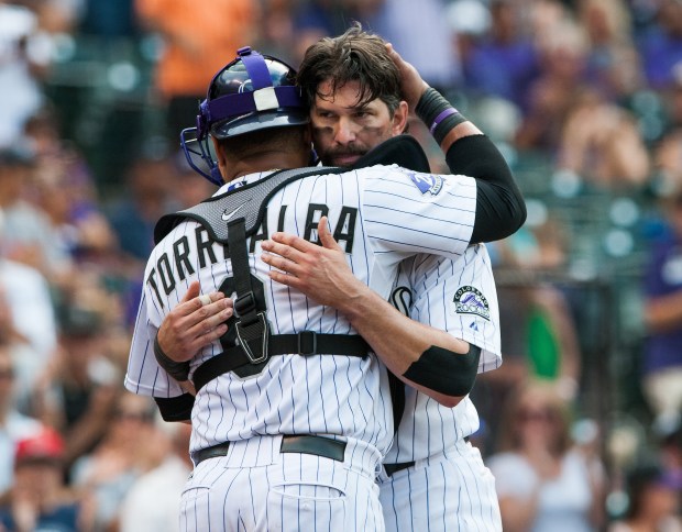 Yorvit Torrealba (8) congratulates Todd Helton (17) of the Colorado Rockies on his 2,500th career hit after the seventh inning of a game against the Cincinnati Reds at Coors Field on Sept. 1, 2013. (Photo by Dustin Bradford/Getty Images)
