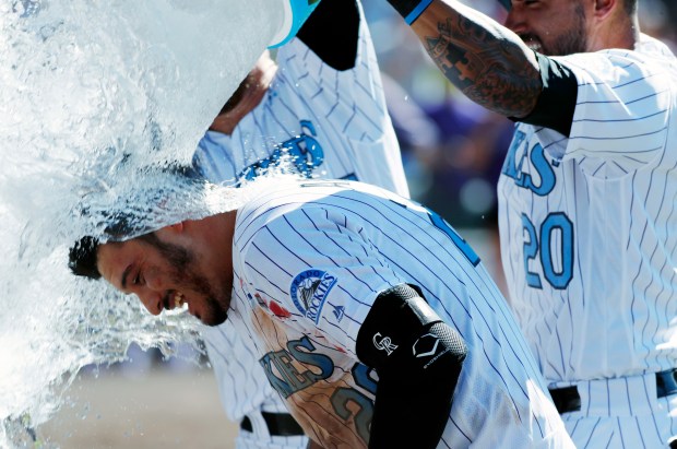 Colorado Rockies' Nolan Arenado, front, is doused by teammates Trevor Story, back left, and Ian Desmond after hitting a walkoff three-run home run off San Francisco Giants relief pitcher Mark Melancon in the ninth inning of a baseball game on June 18, 2017, in Denver. (AP Photo/David Zalubowski)