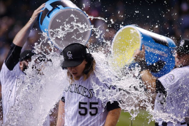 Colorado Rockies starting pitcher Jon Gray, center, is doused after throwing his first shutout game by relief pitcher Jason Motte, left, and catcher Tom Murphy after Gray retired the San Diego Padres in the ninth inning of a baseball game on Sept. 17, 2016, at Coors Field in Denver. (AP Photo/David Zalubowski)