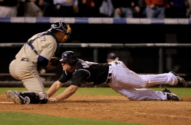 Matt Holliday (5) of the Colorado Rockies dives home with the winning run on a base hit by Jamey Carroll as Michael Barrett (4) of the San Diego Padres tries to control the ball at Coors Field on Oct. 1, 2007, in Denver. (Photo by Doug Pensinger/Getty Images)