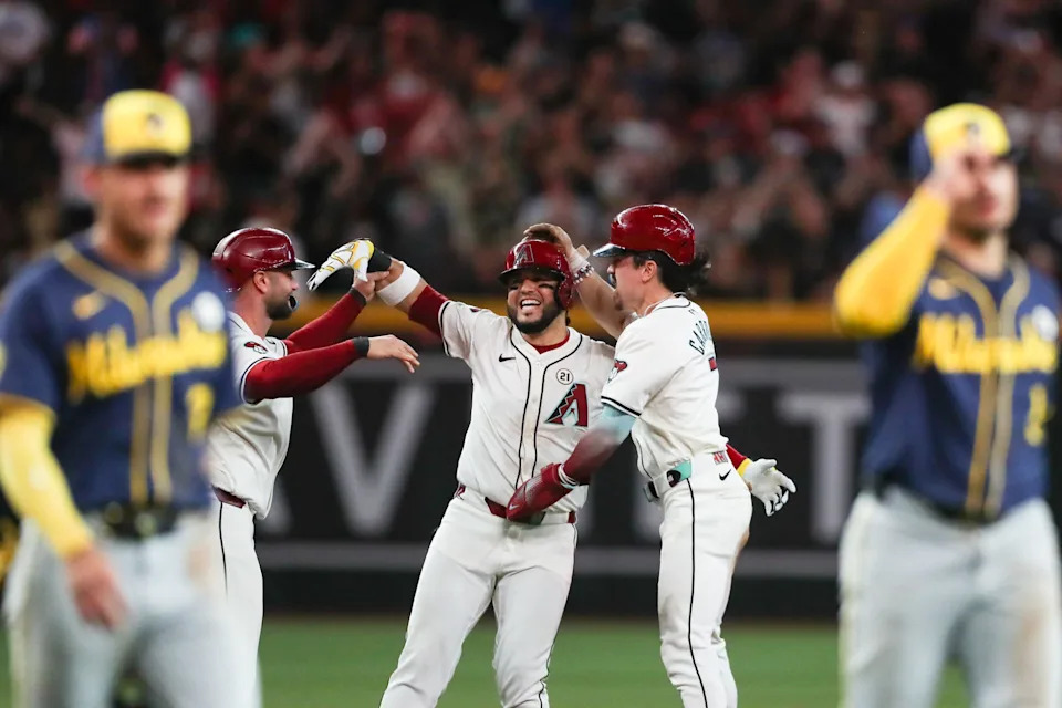 Arizona Diamondbacks third base Eugenio Suarez (28) is mobbed by Arizona Diamondbacks first base Christian Walker (53) and Arizona Diamondbacks outfielder Corbin Carroll (7) after his walk-off hit on Sept. 15, 2024 at Chase Field in Phoenix.