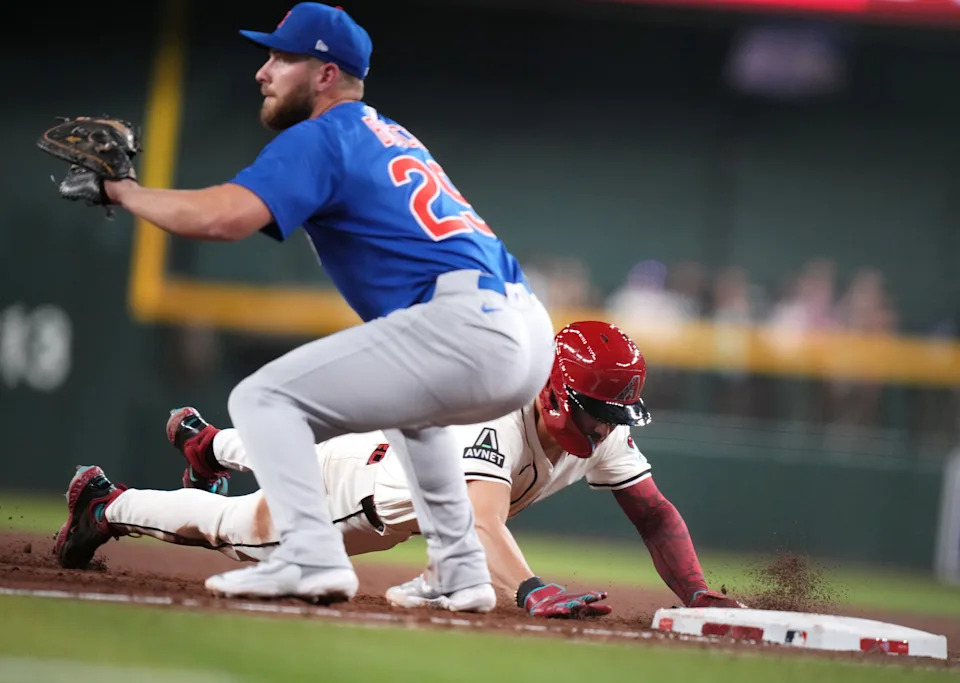 Arizona Diamondbacks Corbin Carroll (7) slides safely back into first base past Chicago Cubs Gage Workman (25) during their Opening Day game at Chase Field in Phoenix on March 27, 2025.