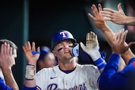Texas Rangers third baseman Josh Jung celebrates with with teammates as he returns to the...