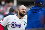 Texas Rangers first baseman Jake Burger talks with pitcher Jacob deGrom in the dugout before...