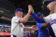 Texas Rangers manager Bruce Bochy, left, celebrates with Wyatt Langford after a baseball...