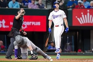 Texas Rangers outfielder Evan Carter reacts after he was hit by a pitch during the seventh...