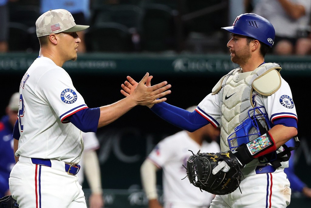 Former Yankee Kyle Higaskioka (right) celebrates with Robert Garcia after the Rangers' win over the Astros on May 17, 2025.