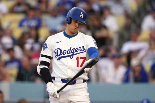 Dodgers star Shohei Ohtani checks his bat after hitting a...
