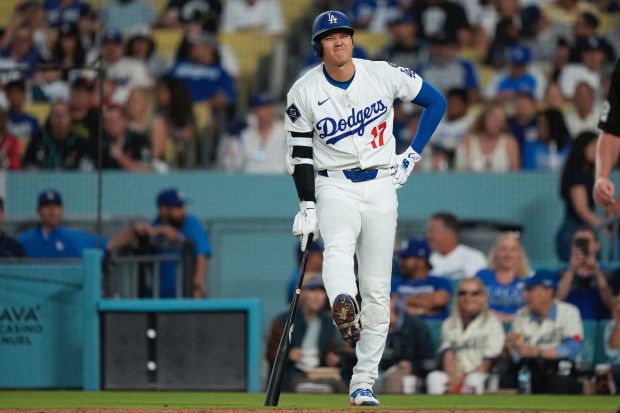 Dodgers star Shohei Ohtani winces after being hit with his...