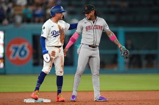 The Dodgers’ Miguel Rojas, left, chats with Arizona Diamondbacks second...