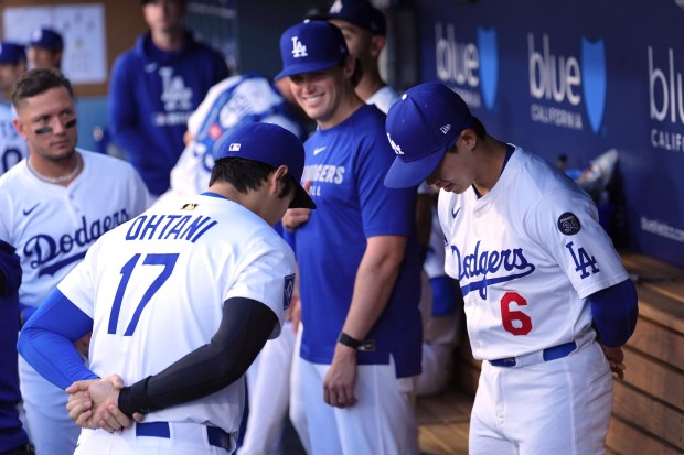 Dodgers star Shohei Ohtani, left, and teammate Hyeseong Kim bow...