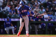 Texas Rangers' Adolis Garcia strikes out swinging during the ninth inning of a baseball game...
