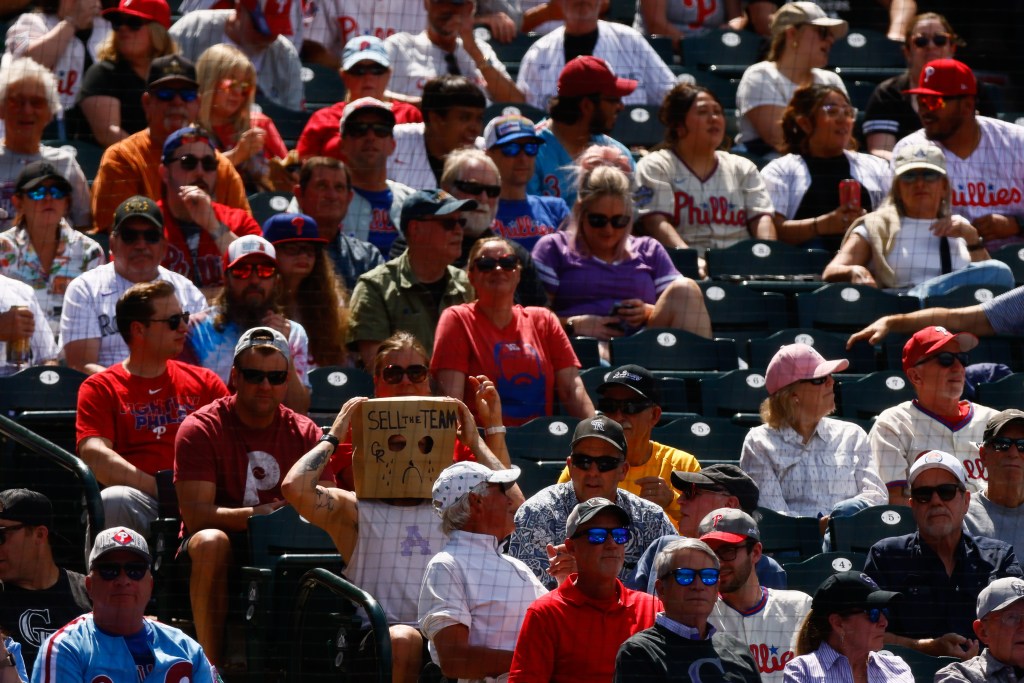 A Colorado Rockies fan wears a paper bag on their head that reads "Sell The Team" in the eighth inning of a game against the Philadelphia Phillies at Coors Field on May 22, 2025 in Denver, Colorado.