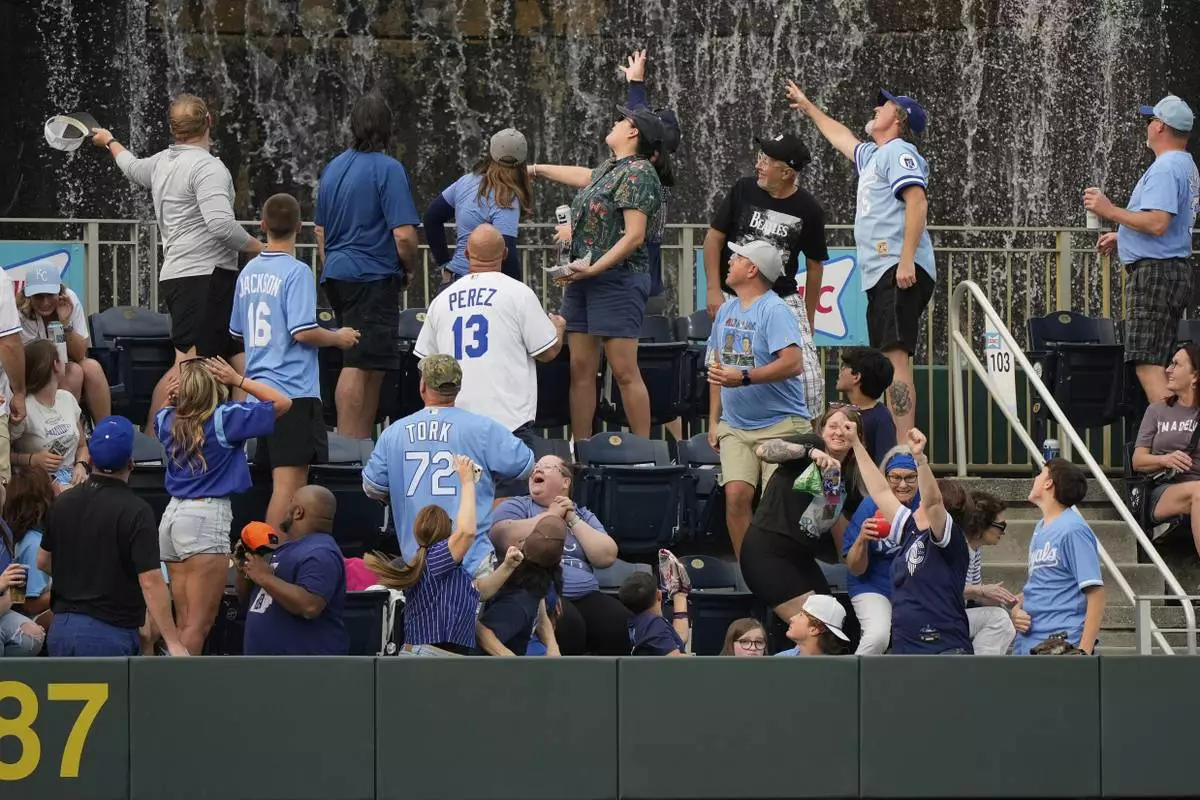 Fans watch a solo home run ball hit by Kansas City Royals' Bobby Witt Jr. during the first inning of a baseball game against the Detroit Tigers, Friday, May 30, 2025, in Kansas City, Mo. (AP Photo/Charlie Riedel)