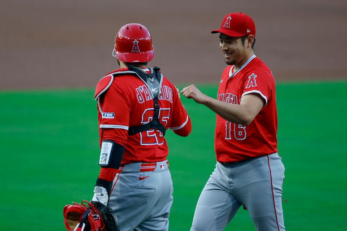 Yusei Kikuchi #16 of the Los Angeles Angels smiles with Travis d'Arnaud #25 after the final out of the first inning against the San Diego Padres at Petco Park on May 12, 2025 in San Diego, California.