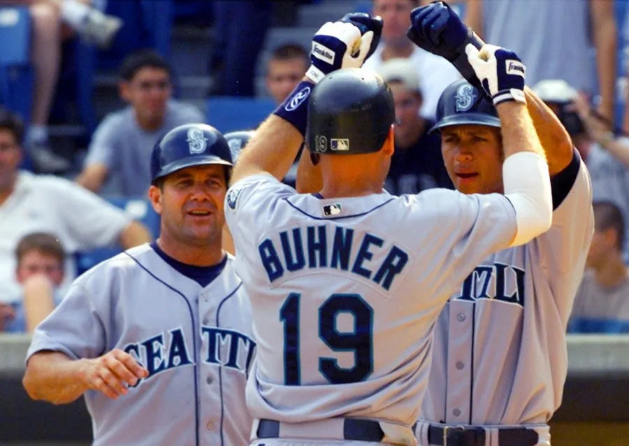 Seattle Mariners’ Jay Buhner (19) is congratulated by teammates Edgar Martinez, left, and Alex Rodriguez after hitting a grand slam in the first inning against the Chicago White Soxin the first game of a doubleheader Tuesday, August 8, 2000 in Chicago. (AP Photo/Fred Jewell)