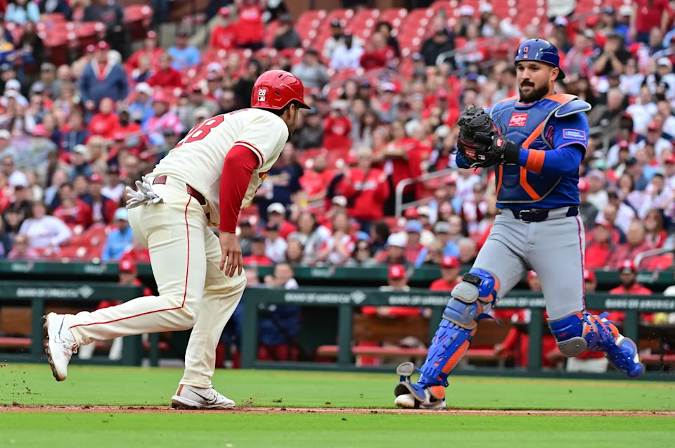 St. Louis Cardinals third baseman Nolan Arenado (28, left) is caught in a rundown between third and home and is eventually tagged out by New York Mets catcher Luis Torrens (13) on May 4, 2025, at Busch Stadium.