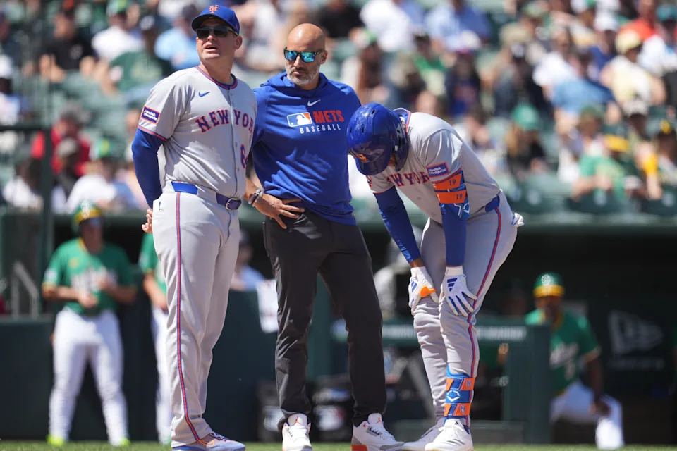 Apr 12, 2025; West Sacramento, California, USA; New York Mets manager Carlos Mendoza (64) stands next to center fielder Jose Siri (19) after Siri suffered an injury against the Athletics in the second inning at Sutter Health Park. Mandatory Credit: Cary Edmondson-Imagn Images