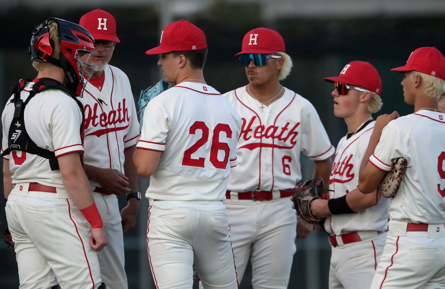 The infield for Heath High School has a meeting with pitcher Ian Ritter (26) in the second...