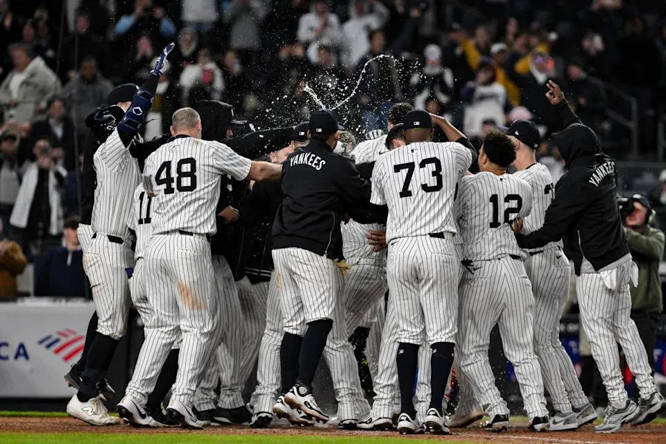 New York Yankees outfielder Jasson Domínguez (24) is mobbed by teammates after hitting a walk off home runJohn Jones-Imagn Images