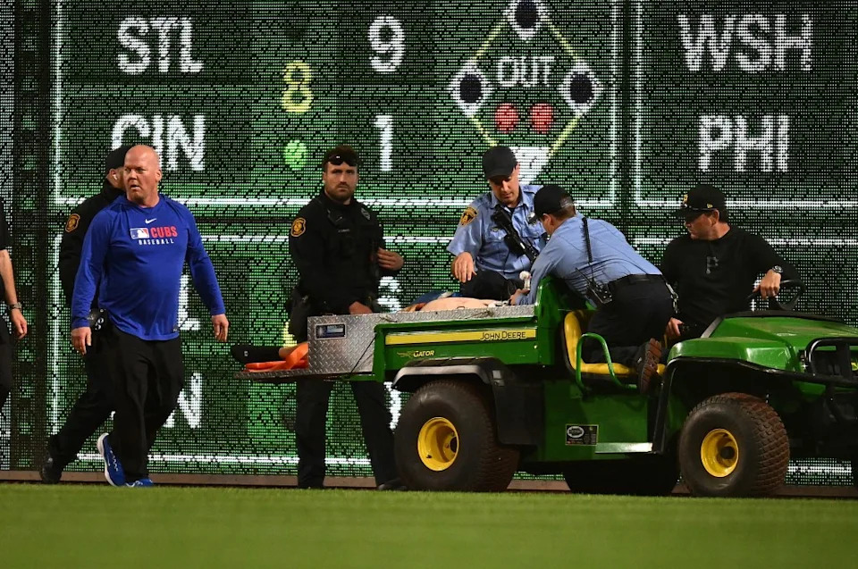 A fan is carted off the field after falling from the stands during the seventh inning of the game. Getty Images