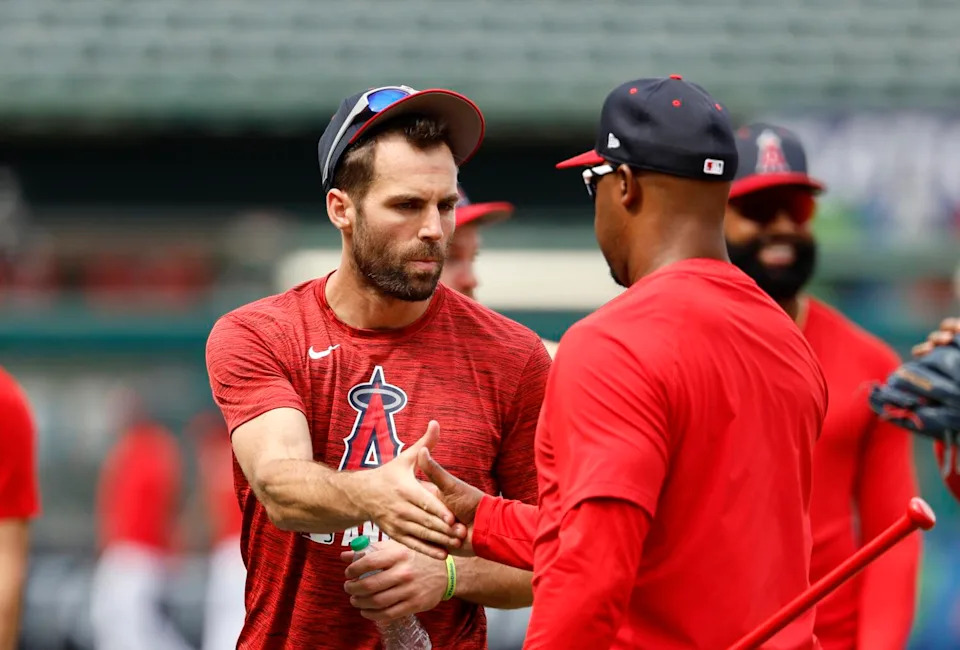 Chris Taylor, left, is greeted by an Angels coach before batting practice at Angel Stadium on May 26.