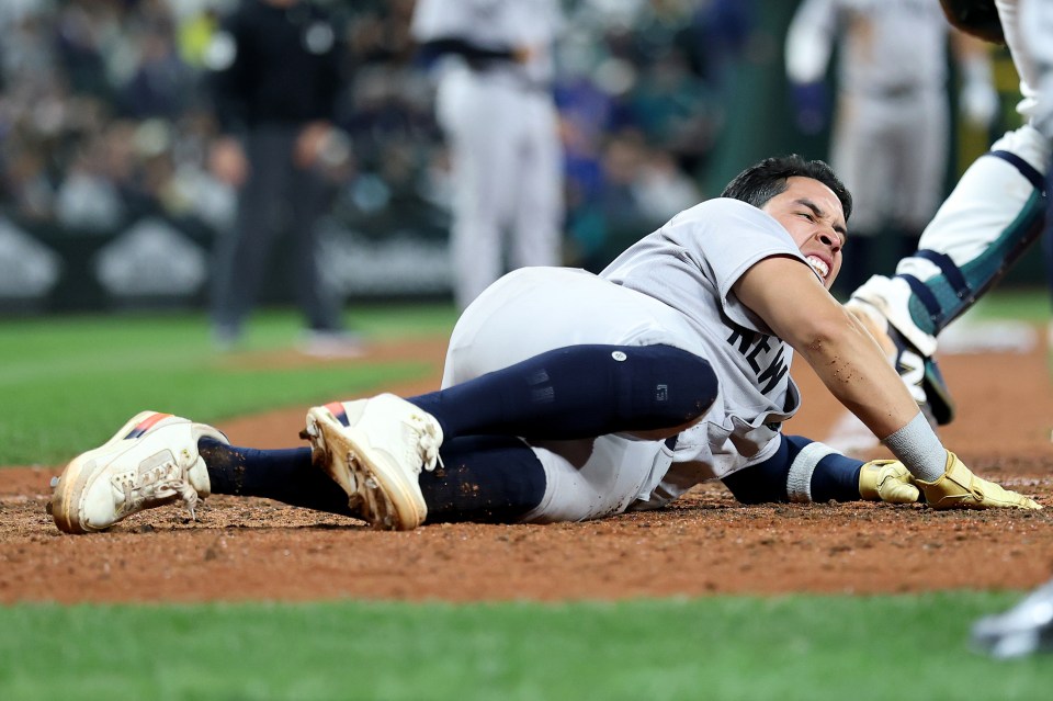 New York Yankees player Oswaldo Cabrera #95 scores a run but is injured.
