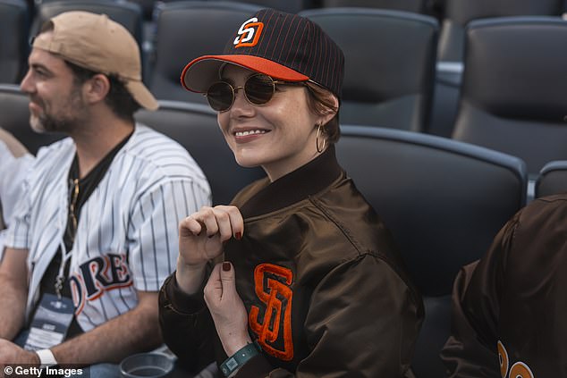 Stone is wearing a Padres' classic brown jacket with the matching hat and sunglasses