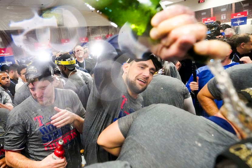 Texas Rangers starting pitcher Nathan Eovaldi douses teammates in the clubhouse as Rangers...