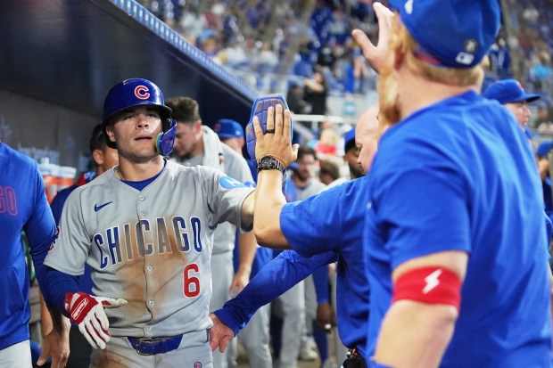 Chicago Cubs' Matt Shaw (6) is congratulated in the dugout after scoring on a single hit by Kyle Tucker during the eighth inning of a baseball game against the Miami Marlins Wednesday, May 21, 2025, in Miami. (AP Photo/Lynne Sladky)