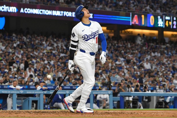 Dodgers star Shohei Ohtani winces after being hit with his...