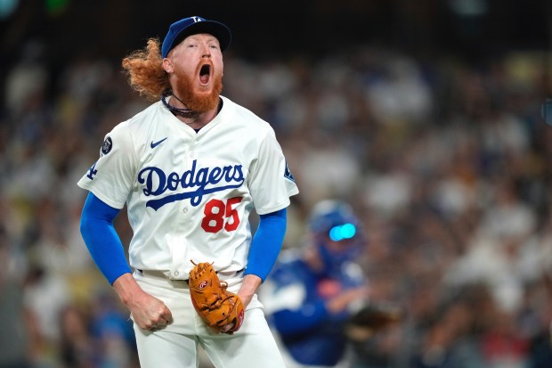 Dodgers starting pitcher Dustin May celebrates after the top of...