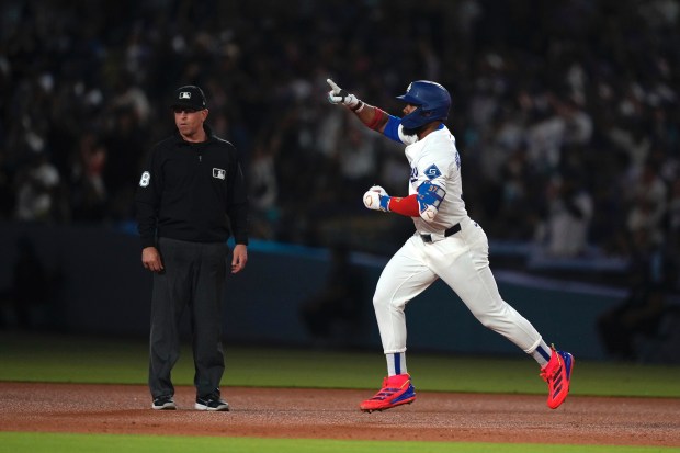 The Dodgers’ Teoscar Hernández, right, gestures as he runs the...