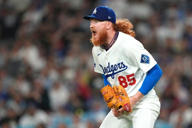 Dodgers starting pitcher Dustin May celebrates after the top of...
