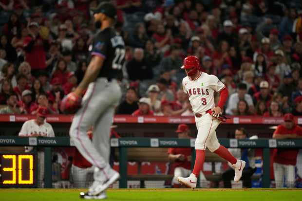 The Angels’ Taylor Ward, right, scores after Travis d’Arnaud was...