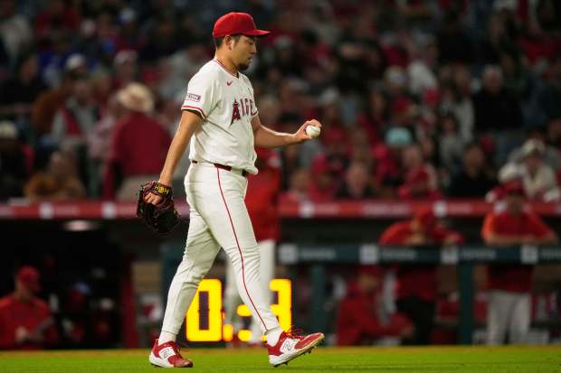 Angels starting pitcher Yusei Kikuchi walks back to the mound...