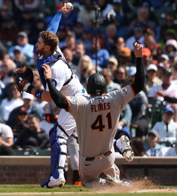 Chicago Cubs catcher Carson Kelly forces San Francisco Giants first baseman Wilmer Flores out at the plate and throws to first for a double play in the sixth inning Wednesday, May 7, 2025, at Wrigley Field. (Brian Cassella/Chicago Tribune)