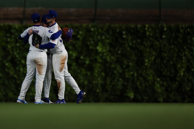 Cubs outfielders embrace after a 2-1 win against the Rockies on May 28, 2025, at Wrigley Field. (Audrey Richardson/Chicago Tribune)