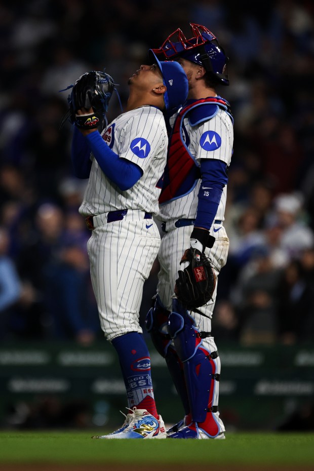 Cubs reliever Daniel Palencia, left, looks skyward next to catcher Carson Kelly after striking out the Rockies' Hunter Goodman to seal a 2-1 win against the Rockies on May 28, 2025, at Wrigley Field. (Audrey Richardson/Chicago Tribune)