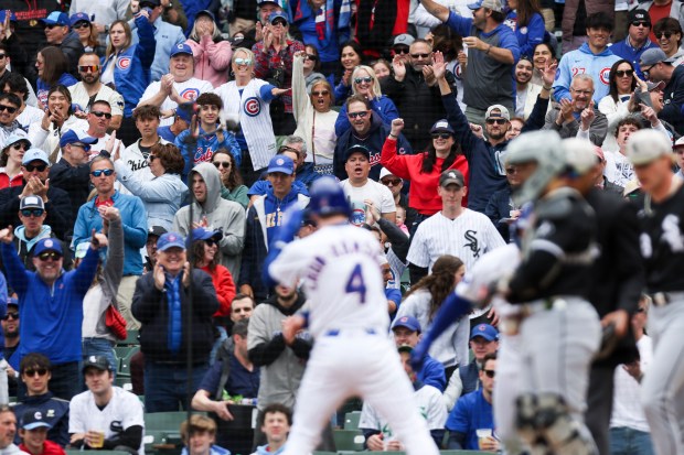 Chicago Cubs outfielder Pete Crow-Armstrong (4) celebrates with fans after sliding in safely to home after outfielder Seiya Suzuki (27) hit a sacrifice fly in the first inning against the Chicago White Sox at Wrigley Field on Sunday, May 18, 2025. (Eileen T. Meslar/Chicago Tribune)