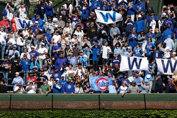 Chicago Cubs fans in the bleachers celebrate and hold up "W" flags after the Chicago Cubs defeated the Chicago White Sox 6-2 at Wrigley Field on Sunday, May 18, 2025. (Eileen T. Meslar/Chicago Tribune)