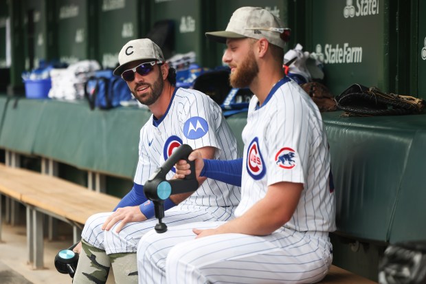 Chicago Cubs shortstop Dansby Swanson (7) and first baseman Michael Busch (29) chat while they use massage guns on their legs before their game against the Chicago White Sox at Wrigley Field on Sunday, May 18, 2025. (Eileen T. Meslar/Chicago Tribune)