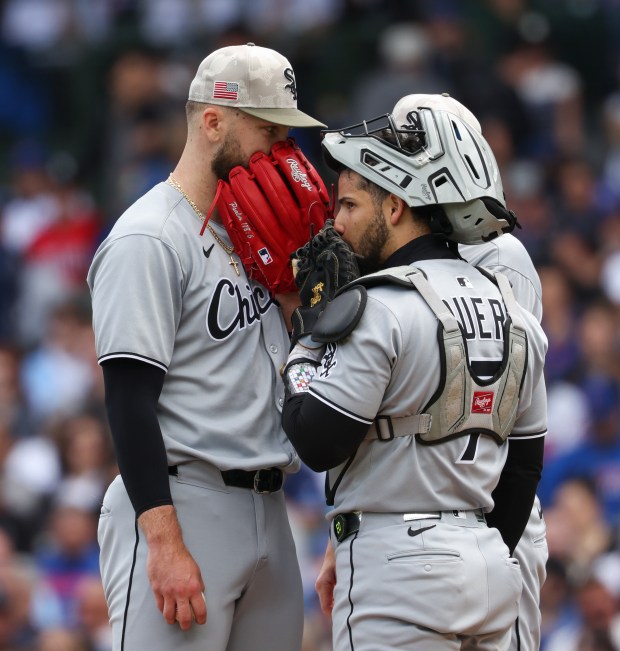 White Sox starter Sean Burke, left, and catcher Edgar Quero cover their mouths while having a meeting on the mound in the second inning against the Cubs on May 17, 2025, at Wrigley Field. (John J. Kim/Chicago Tribune)