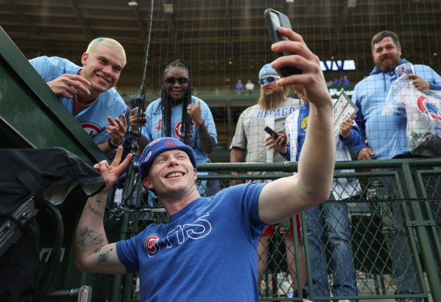 Cubs center fielder Pete Crow-Armstrong takes a selfie for a fan with a similar hairdo after a 7-3 win over the White Sox on May 17, 2025, at Wrigley Field. (John J. Kim/Chicago Tribune)