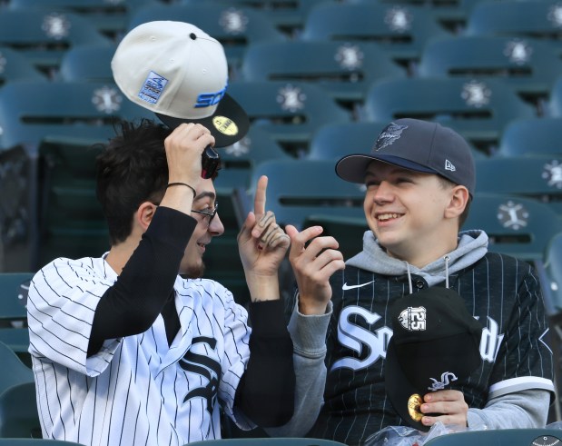 A White Sox fan tries on a newly-purchased cap before a White Sox-Rangers game at Rate Field on May 23, 2025, in Chicago. (John J. Kim/Chicago Tribune)