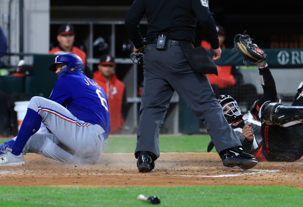 White Sox catcher Edgar Quero, right, holds up his mitt for the umpire after tagging out Rangers third baseman Josh Jung in the sixth inning on May 23, 2025, at Rate Field. (John J. Kim/Chicago Tribune)
