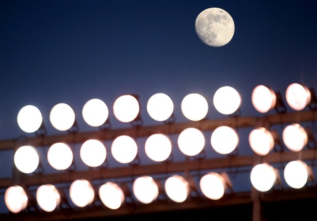 The moon rises above the lights of Wrigley Field during a game between the Cubs and Marlins on June 6, 2017. (Chris Sweda/Chicago Tribune)