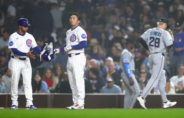 Chicago Cubs left fielder Seiya Suzuki hands over his helmet after grounding out to end the eighth inning of a game against the Miami Marlins at Wrigley Field in Chicago on May 14, 2025. (Chris Sweda/Chicago Tribune)