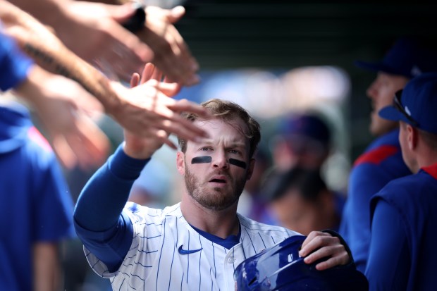 Chicago Cubs outfielder Ian Happ is congratulated in the dugout after scoring on a ground out by teammate Dansby Swanson in the first inning of a game against the Colorado Rockies at Wrigley Field in Chicago on May 26, 2025. (Chris Sweda/Chicago Tribune)